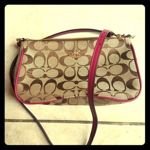 Small Coach logo purse with pink shoulder strap